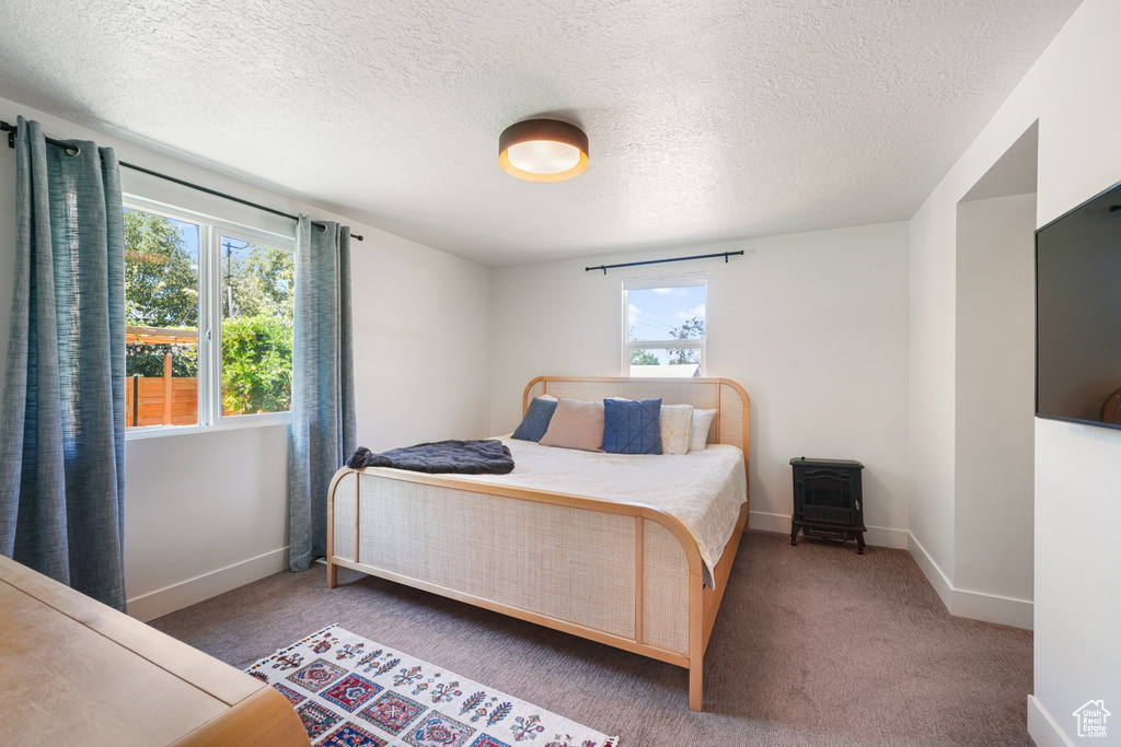 Bedroom with a textured ceiling and carpet flooring
