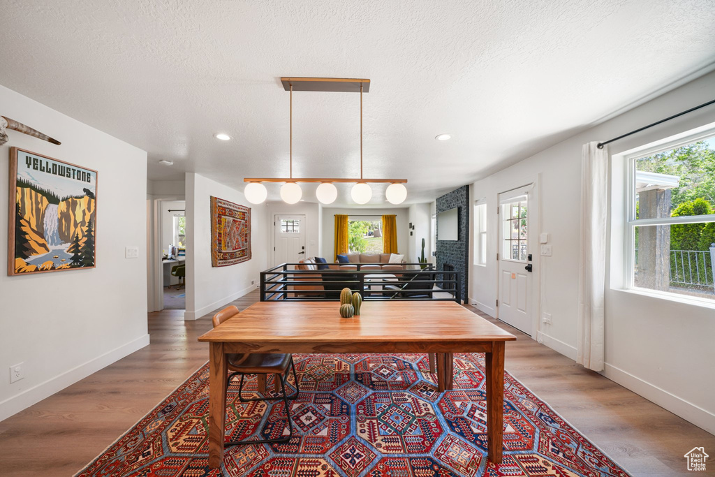 Dining room with wood finished floors, recessed lighting, and a textured ceiling