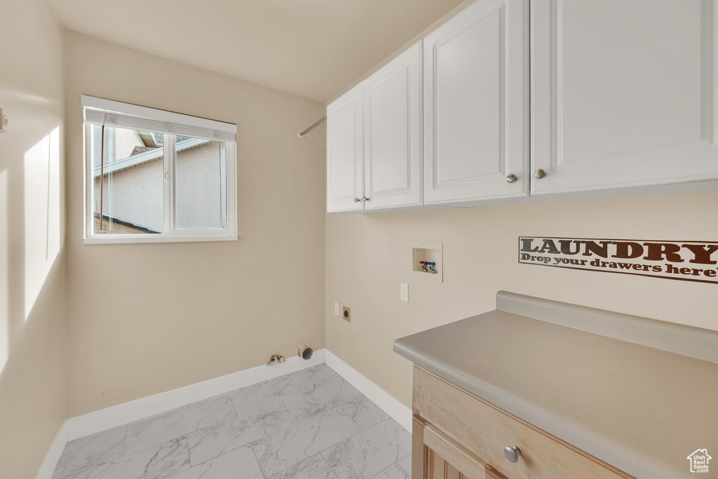 Laundry room featuring cabinet space, hookup for an electric dryer, washer hookup, and light marble finish flooring