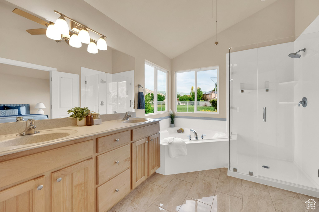 Full bathroom with a shower stall, a bath, double vanity, high vaulted ceiling, and ensuite bathroom