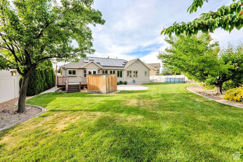 Fenced yard with a wooden deck and a patio area