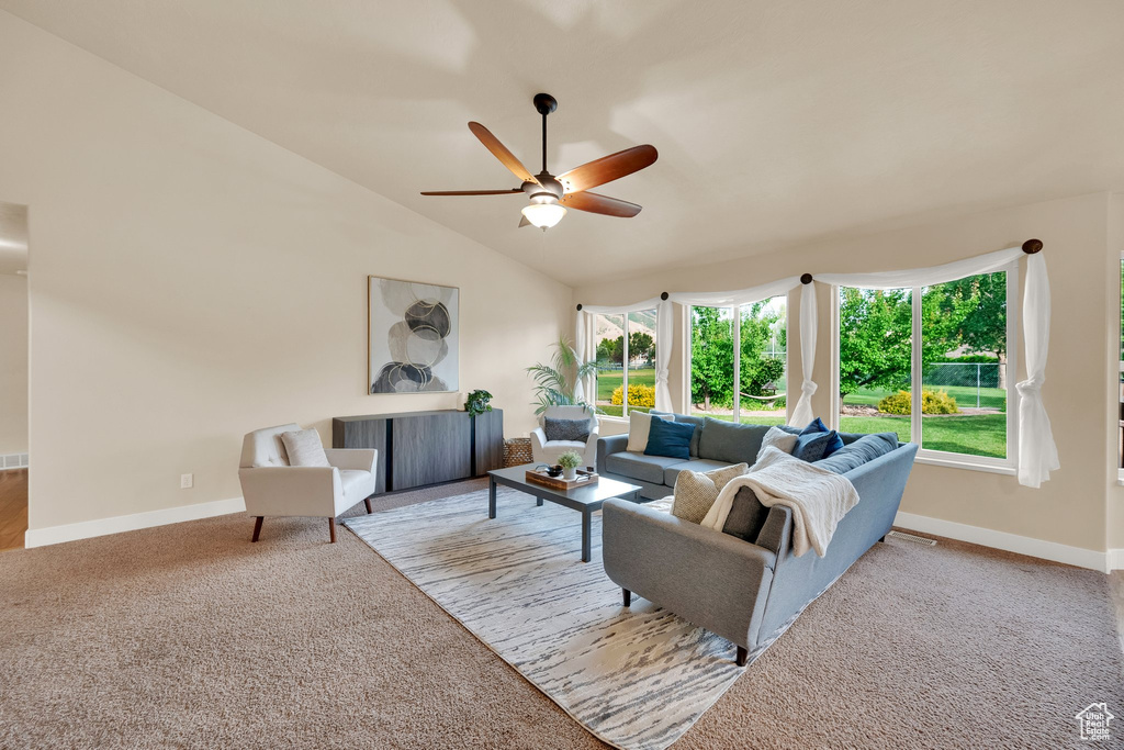Living room featuring a ceiling fan, healthy amount of natural light, carpet floors, and vaulted ceiling
