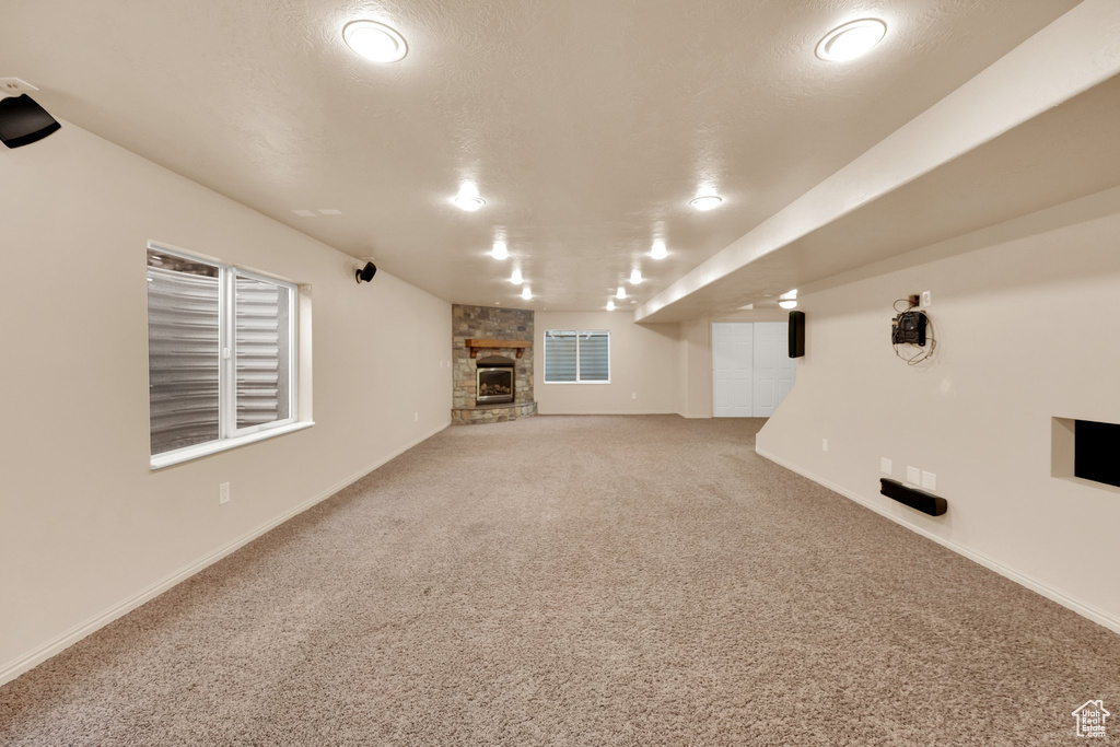 Unfurnished living room with carpet floors and a fireplace