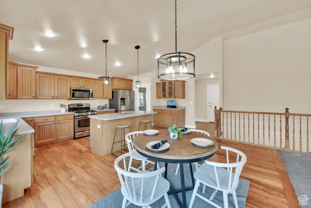 Dining room with light wood-style flooring and lofted ceiling