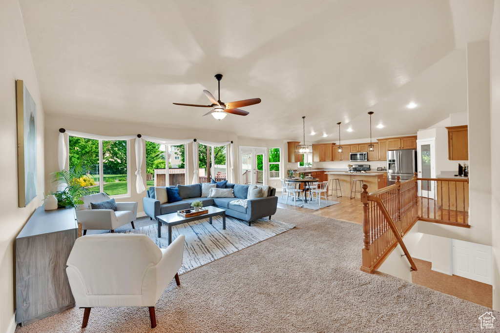 Living room featuring ceiling fan, light carpet, and recessed lighting