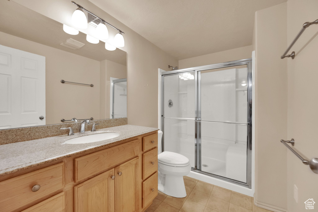 Bathroom with a shower stall, vanity, and tile patterned flooring