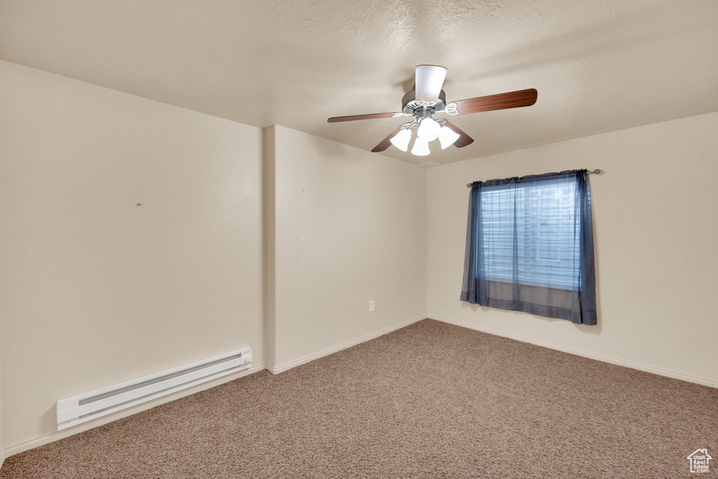 Spare room with baseboard heating, carpet flooring, and a ceiling fan