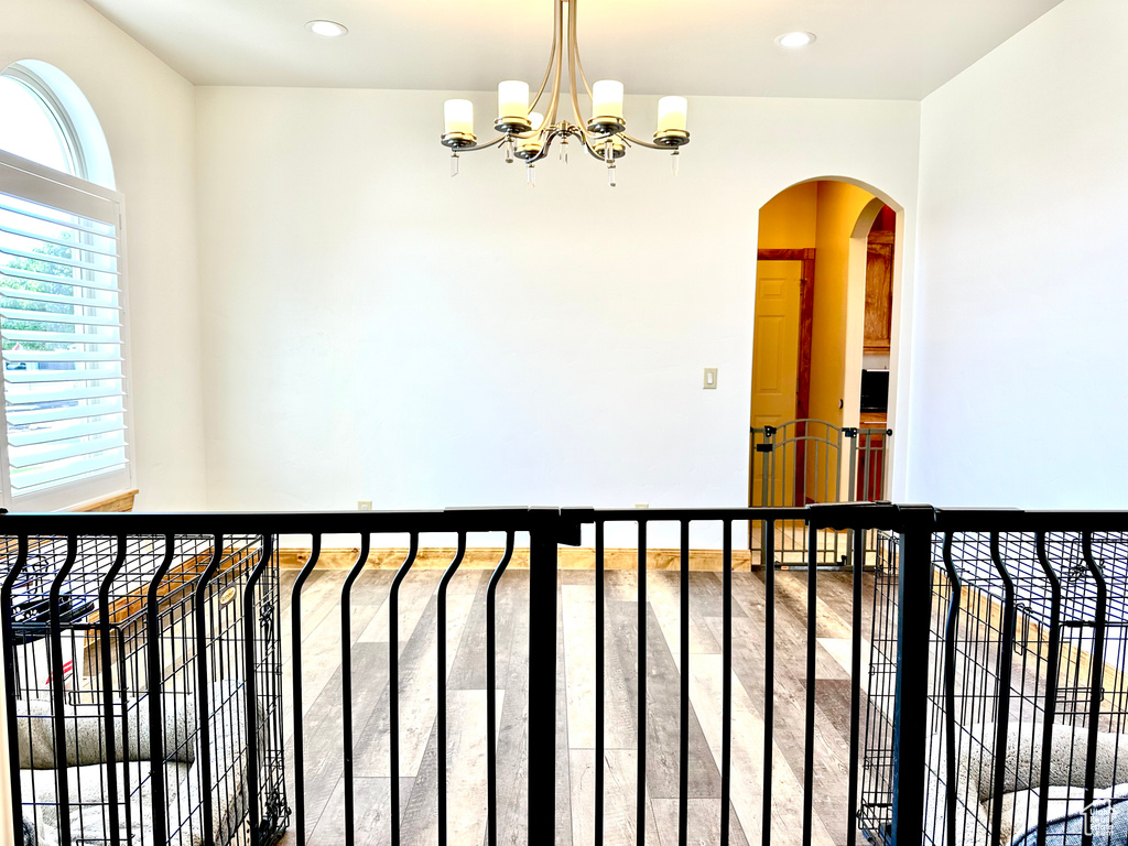 Interior space featuring arched walkways, a chandelier, recessed lighting, and wood finished floors