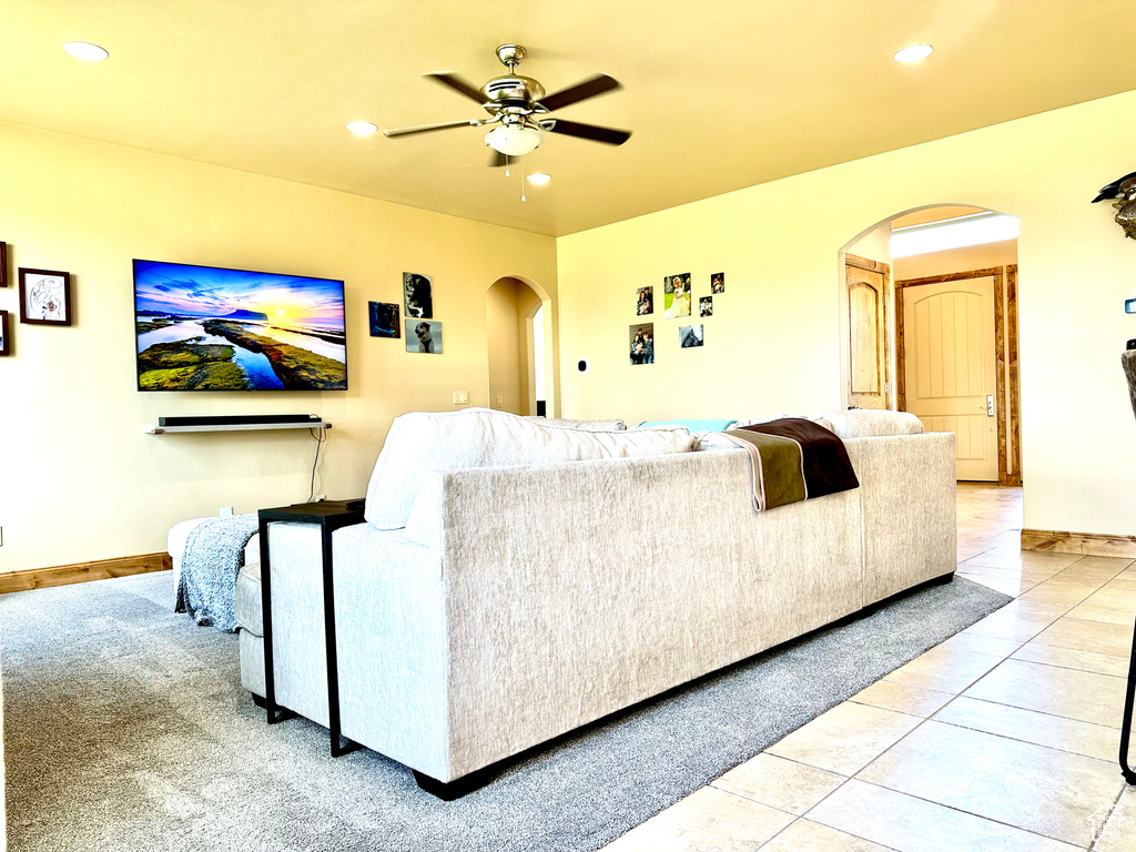 Living area with arched walkways, a ceiling fan, and recessed lighting