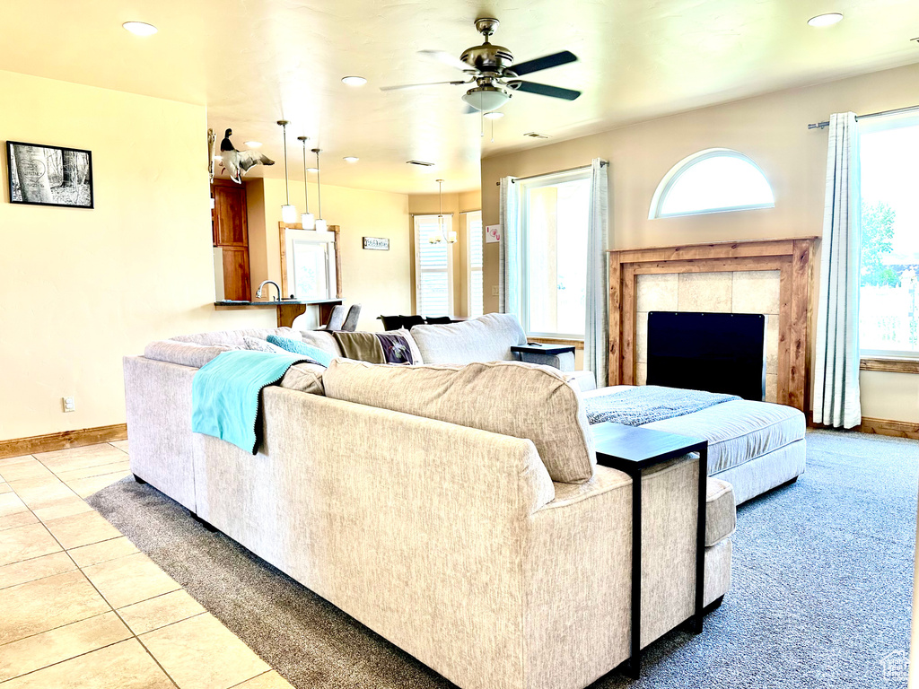 Living room with a ceiling fan, healthy amount of natural light, recessed lighting, tile patterned floors, and a fireplace