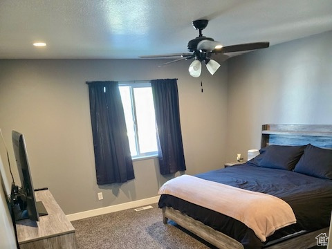 Carpeted bedroom featuring baseboards and ceiling fan