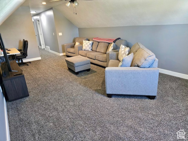Carpeted living area with vaulted ceiling and ceiling fan
