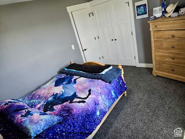 Carpeted bedroom with a closet and baseboards