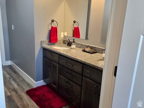 Full bath with double vanity and wood finished floors