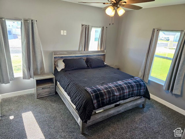 Carpeted bedroom featuring multiple windows and a ceiling fan