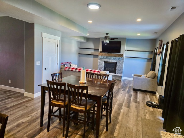 Dining space featuring ceiling fan, wood finished floors, a fireplace, and recessed lighting