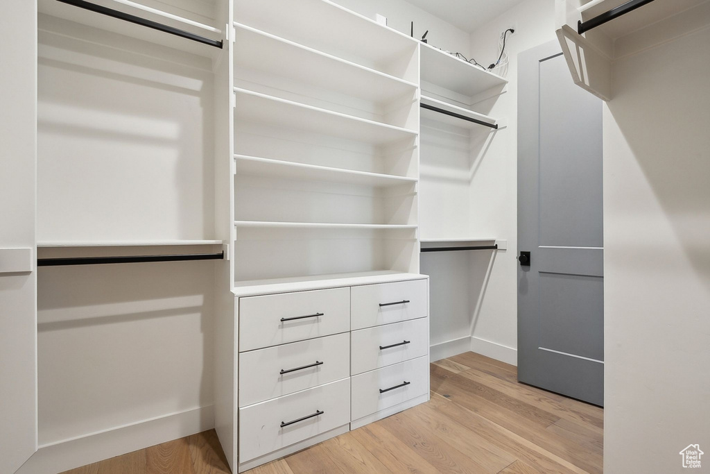 Walk in closet with light wood-style floors