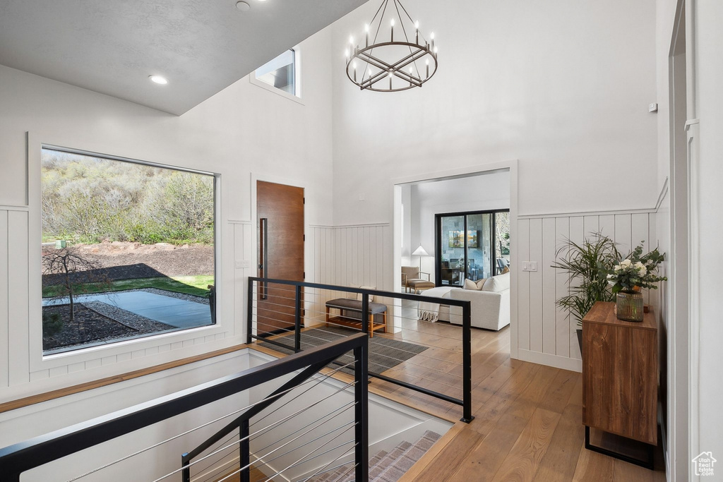 Corridor featuring wood-type flooring, a wainscoted wall, a chandelier, an upstairs landing, and recessed lighting
