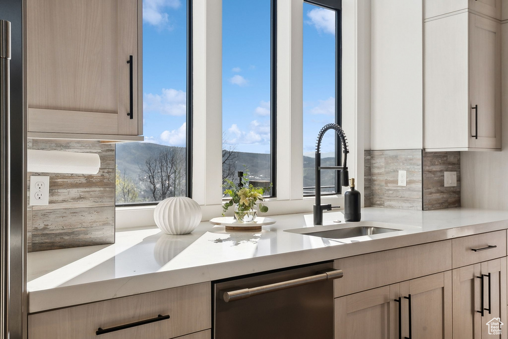 Kitchen featuring dishwasher, tasteful backsplash, light countertops, and a mountain view