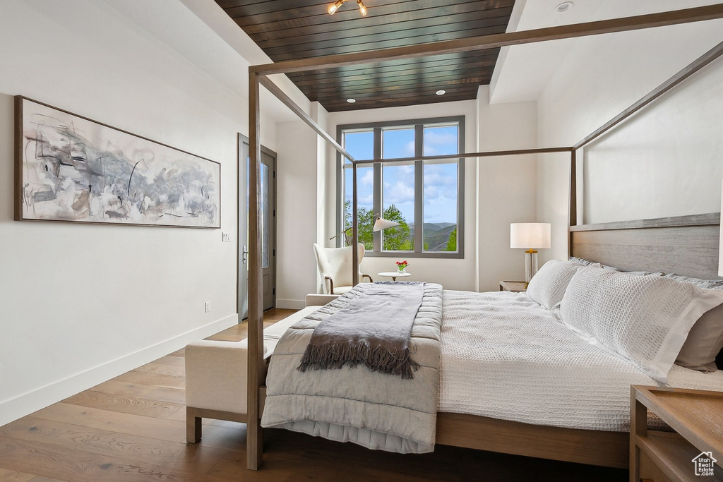 Bedroom featuring wood finished floors and wood ceiling