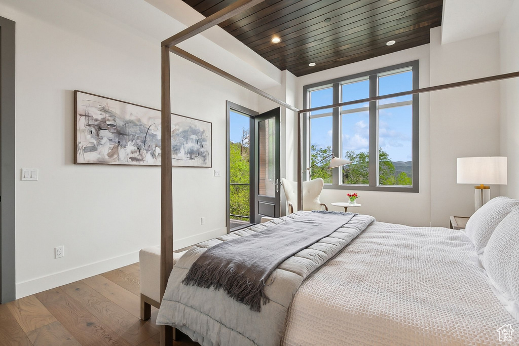 Bedroom featuring wood finished floors, access to outside, multiple windows, and recessed lighting