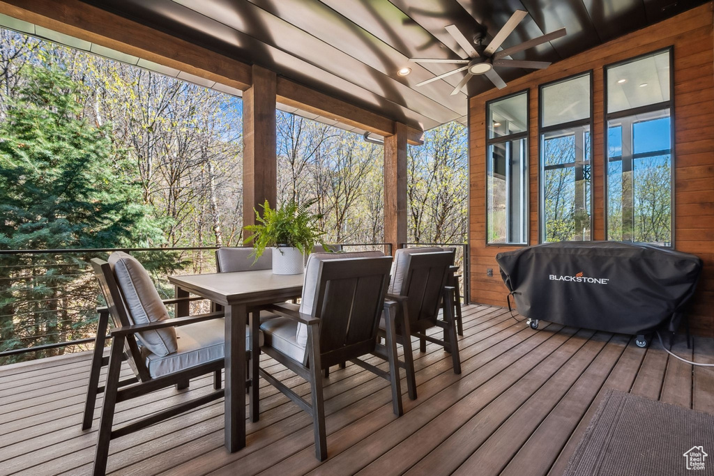 Wooden terrace featuring ceiling fan, outdoor dining space, and area for grilling
