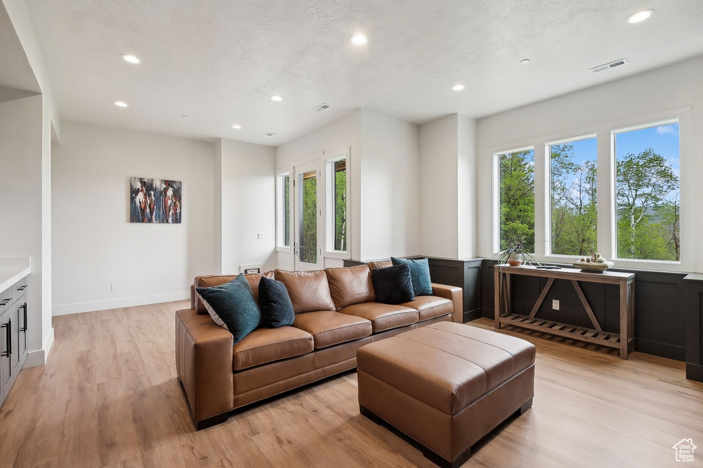 Living area with recessed lighting, healthy amount of natural light, and light wood-style floors