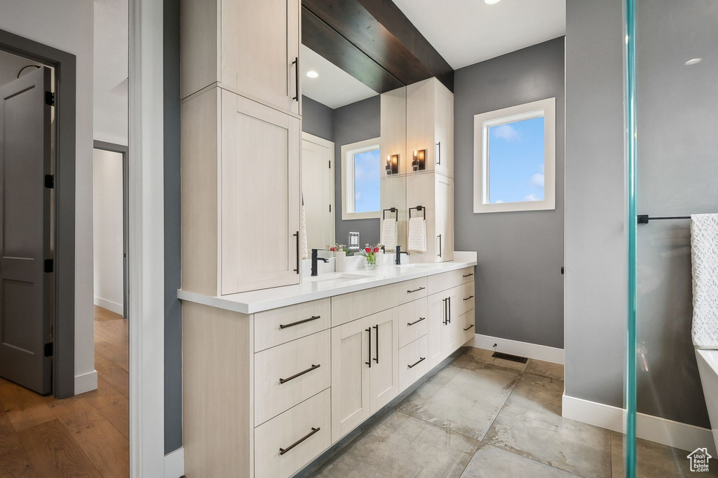 Bathroom with baseboards and double vanity