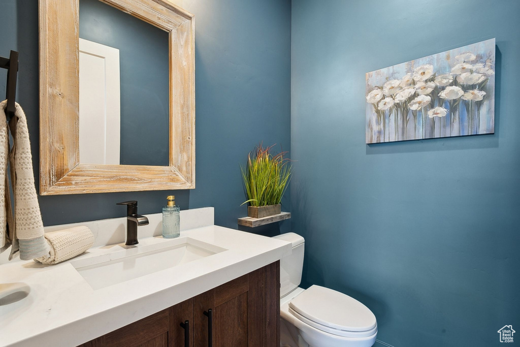 Half bath featuring toilet and vanity