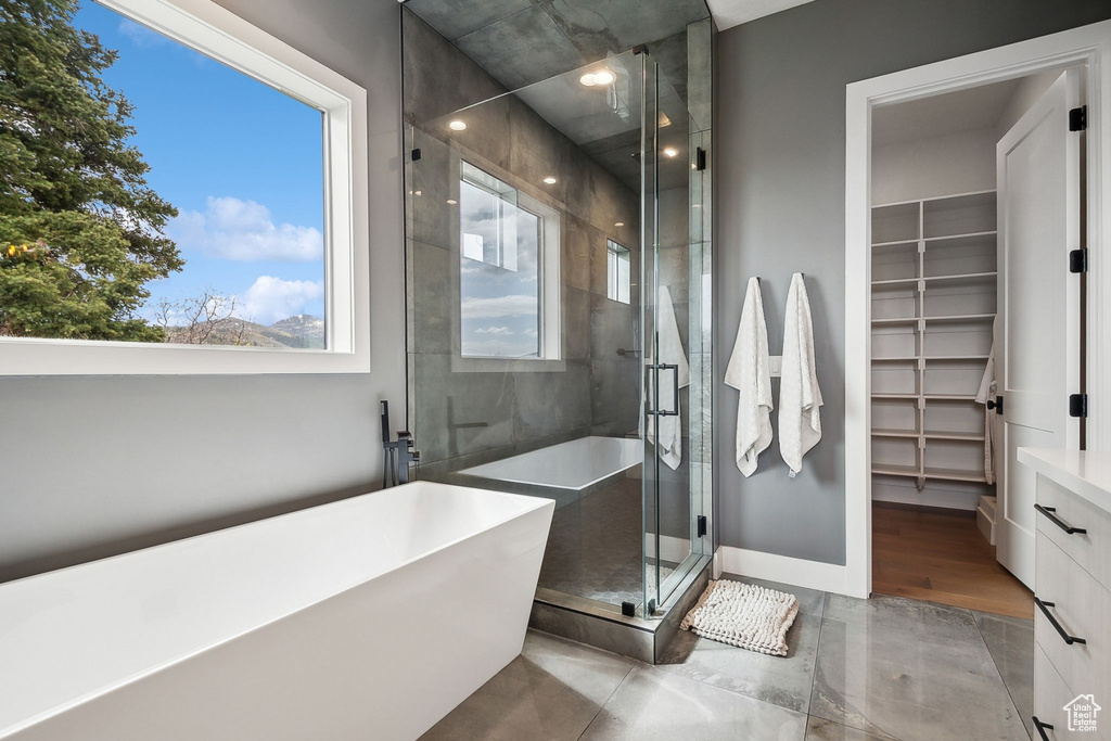 Full bathroom with a freestanding bath, a spacious closet, and a stall shower