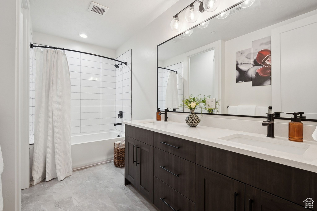 Full bathroom with double vanity and shower / tub combo with curtain