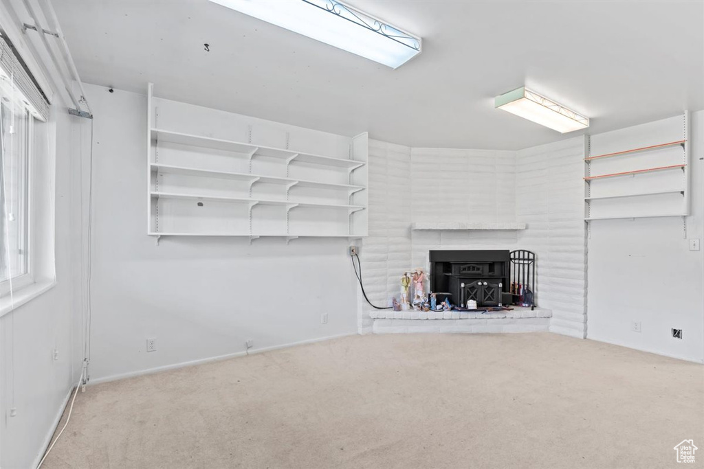 Unfurnished living room featuring carpet and baseboards