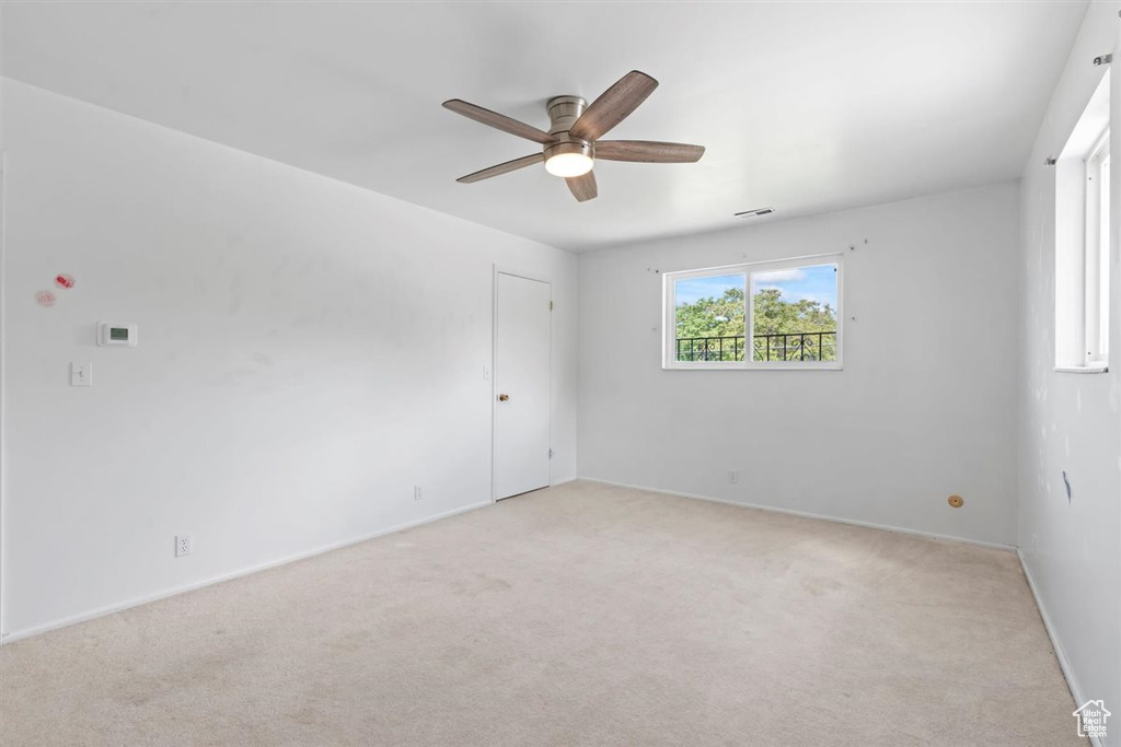 Spare room featuring ceiling fan and light colored carpet