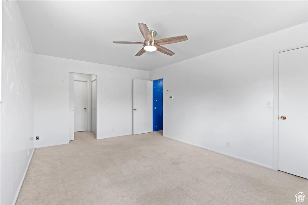 Unfurnished bedroom featuring light colored carpet and a ceiling fan