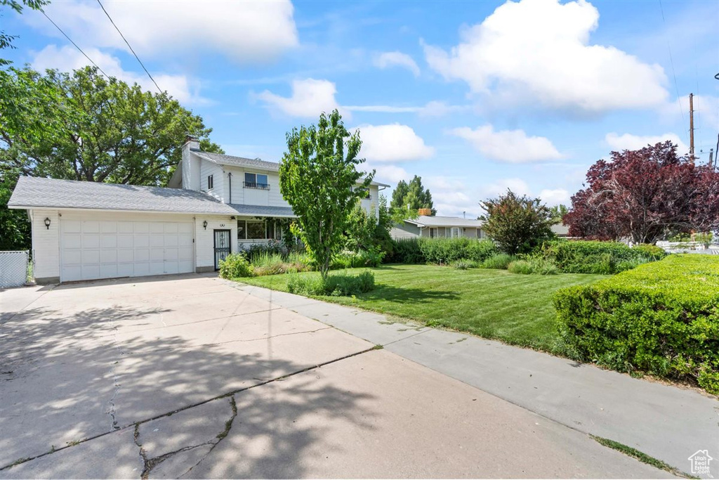 View of front of house with an attached garage and concrete driveway