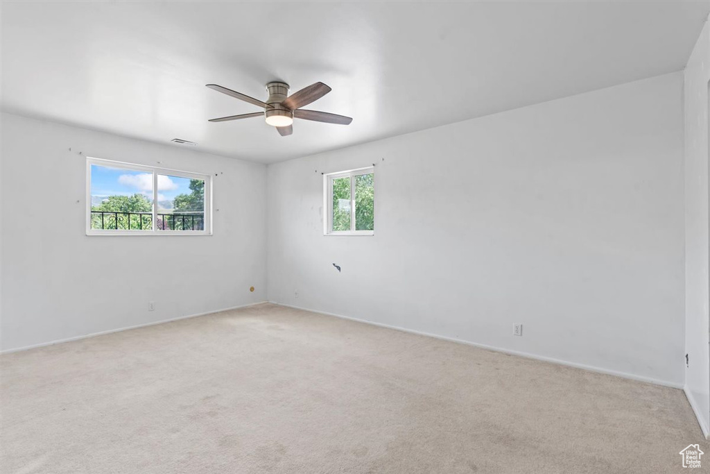 Unfurnished room featuring light carpet and ceiling fan
