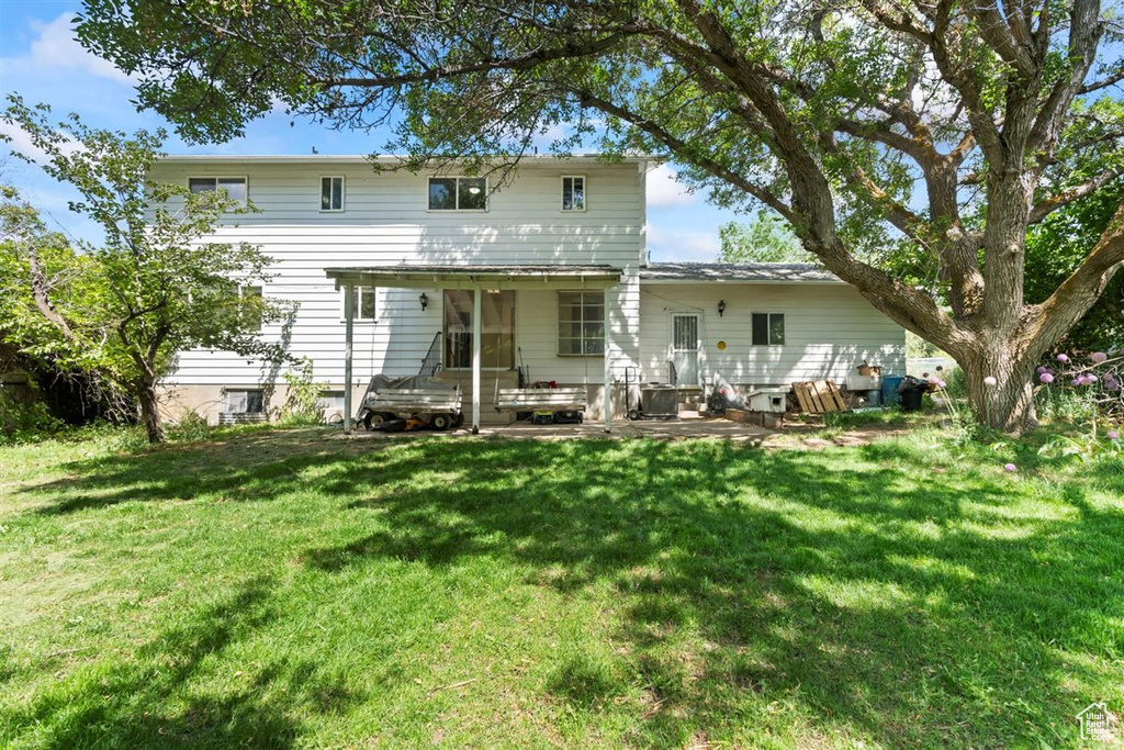 Back of property featuring a yard and a patio area