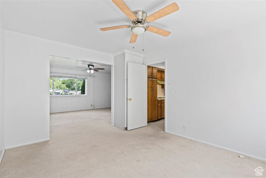 Empty room with light carpet and ceiling fan