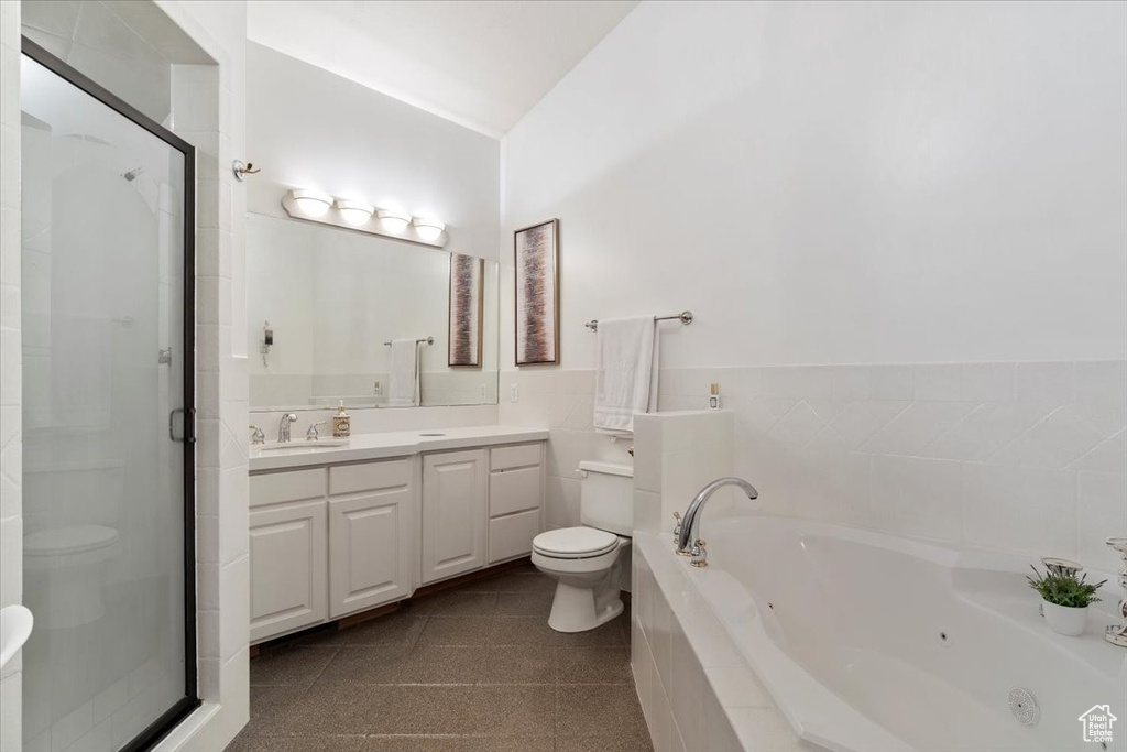 Full bathroom featuring vanity, a jetted tub, and a stall shower