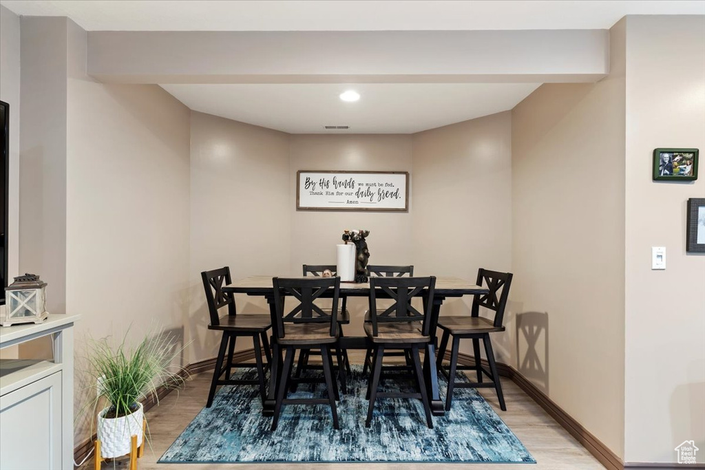 Dining room with light wood finished floors and recessed lighting