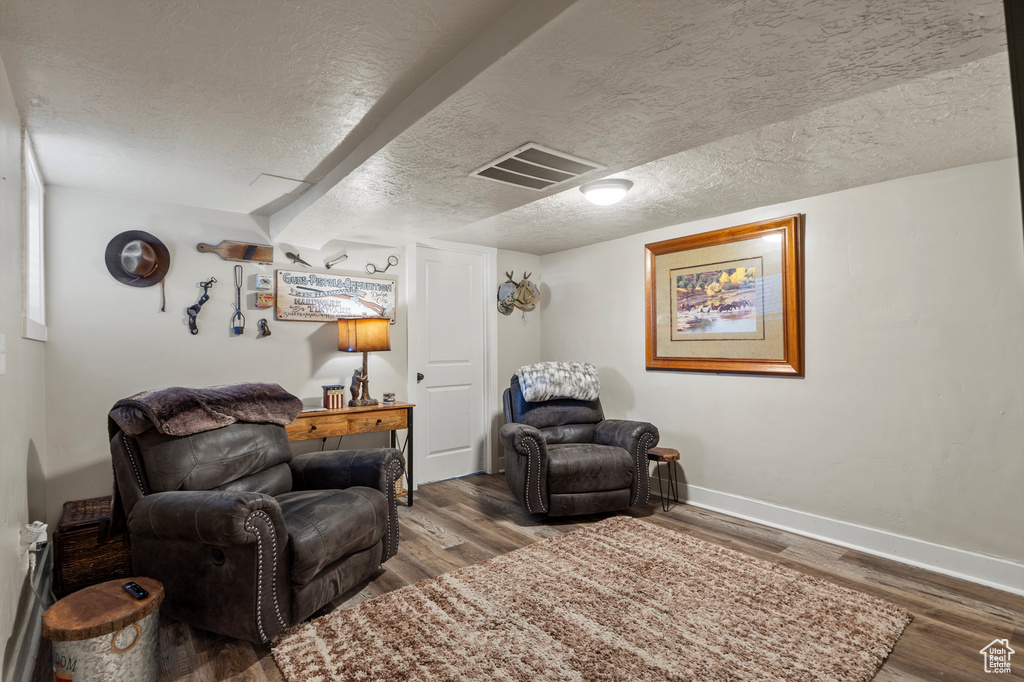 Living area featuring wood finished floors and a textured ceiling