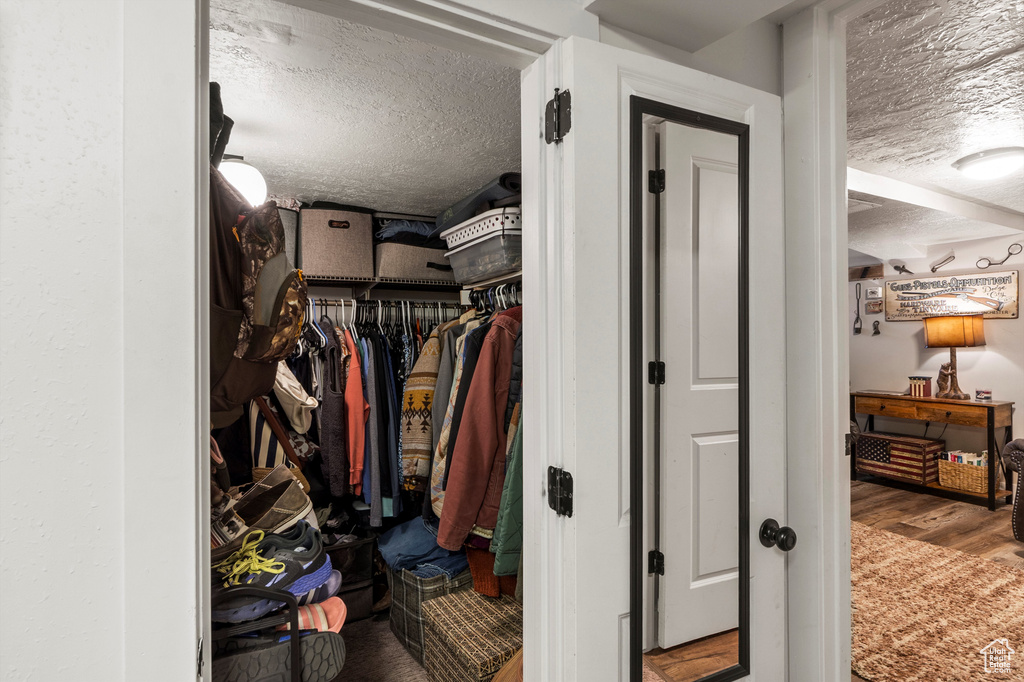 Walk in closet with wood finished floors