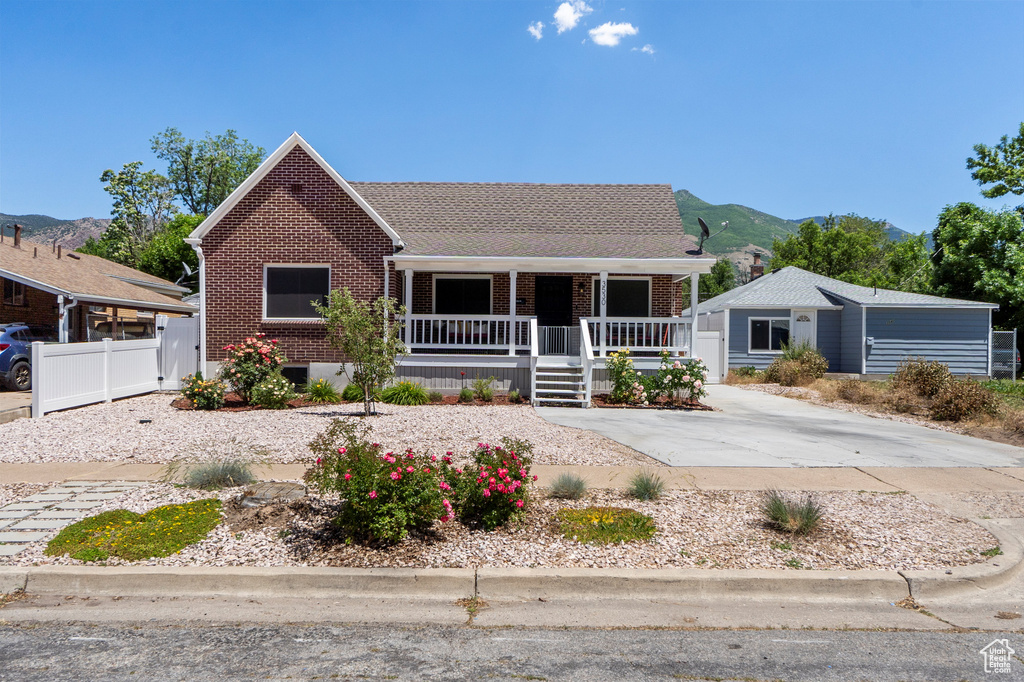 View of front of home with a porch, brick siding, and a mountain view