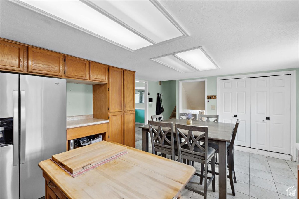 Dining area with light tile patterned floors and a textured ceiling