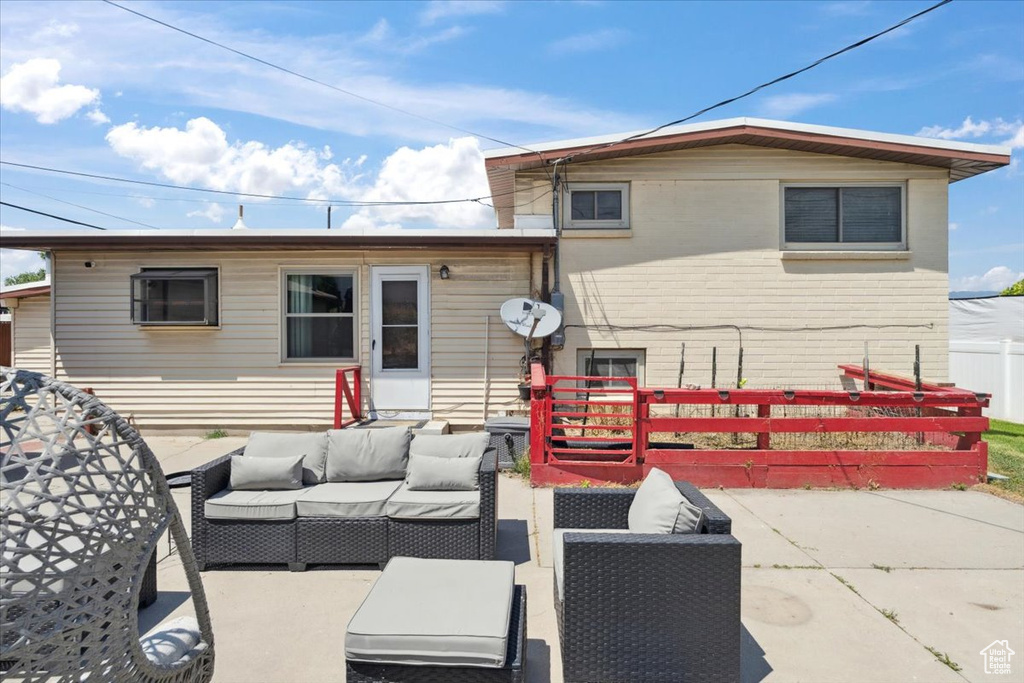Back of property featuring an outdoor living space and a patio area