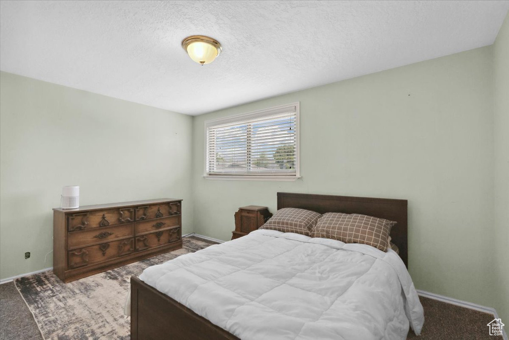 Bedroom featuring baseboards and a textured ceiling
