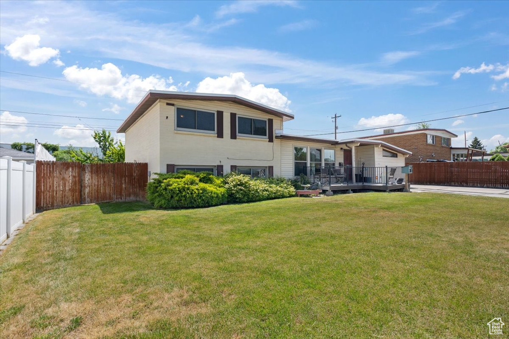 Rear view of house featuring a fenced backyard and a wooden deck
