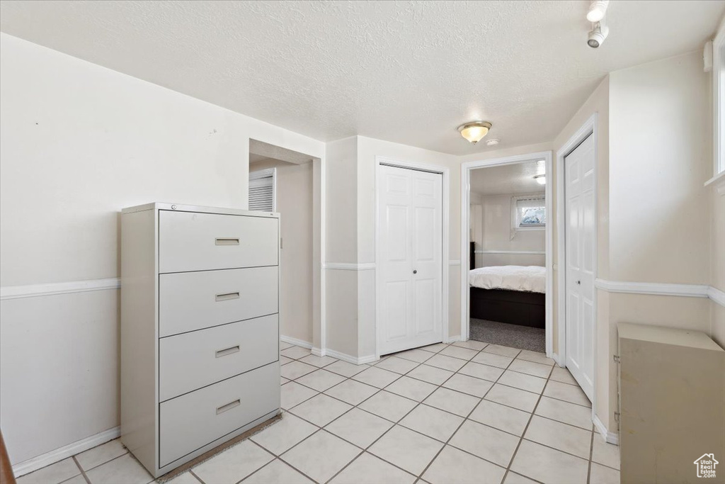 Unfurnished bedroom with a textured ceiling and light tile patterned floors