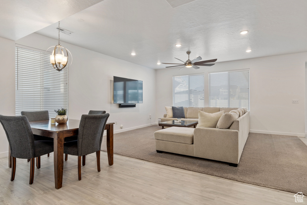 Dining space featuring baseboards, light wood-style floors, a ceiling fan, recessed lighting, and a chandelier