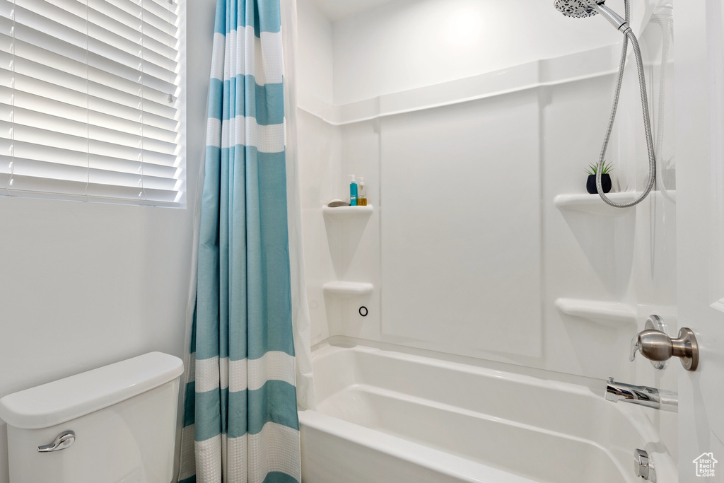 Full bath featuring shower / bathtub combination with curtain and toilet